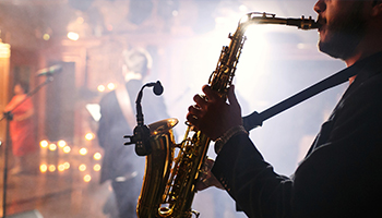 Man playing saxophone on stage at a night club